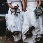 Brides in boots holding bouquets in the back of a truck