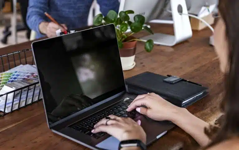 Woman working on laptop in an office environment.