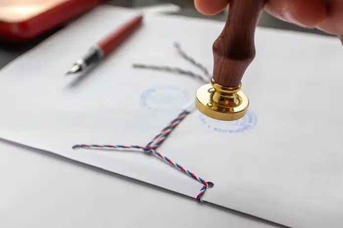 Sealing wax stamp on envelope with embossed seal.