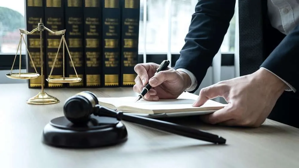 Lawyer reviewing documents with scales of justice.