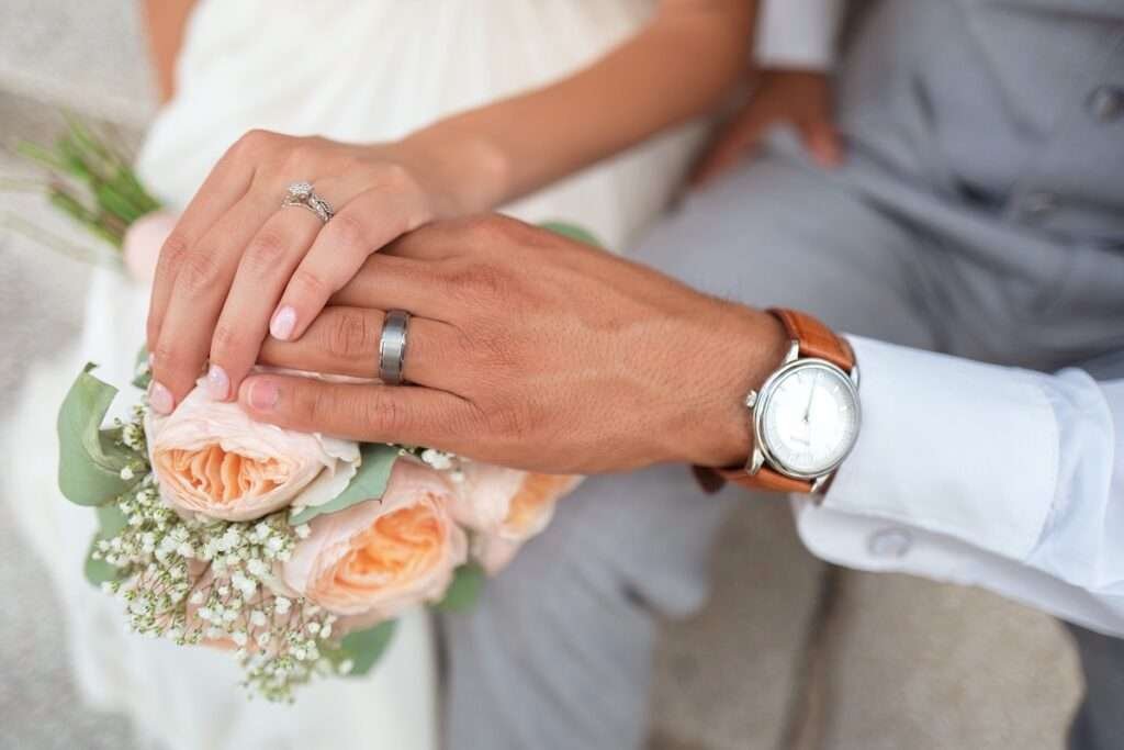 Close-up of a newlywed couple's hands with rings.