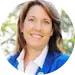 Smiling woman outdoors in business attire.