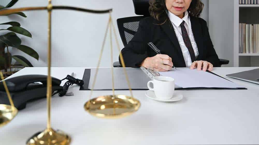 Lawyer working at desk with scales of justice.