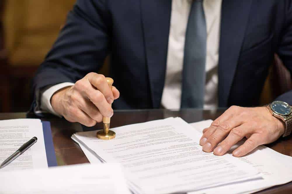 Businessman sealing document with notary public stamp.