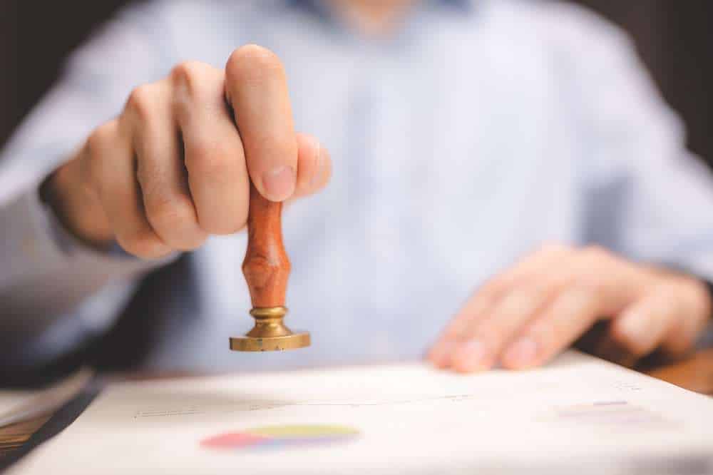 Person using a wooden stamp on document