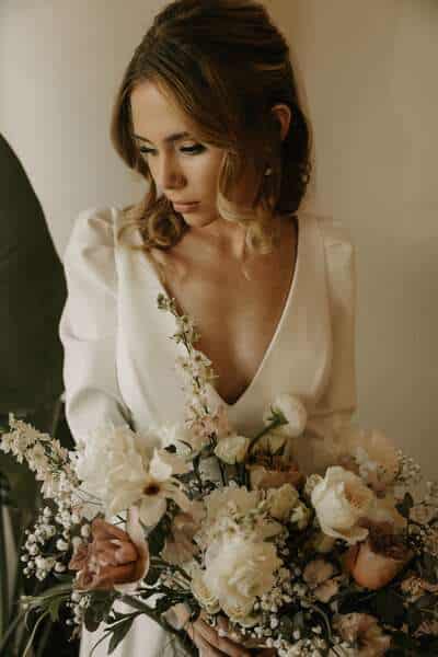 Bride holding white floral bouquet.