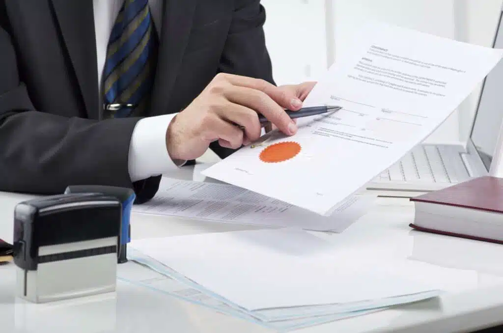 Person reviewing and stamping official document.