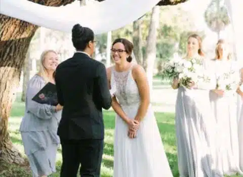 Outdoor wedding ceremony with smiling bride and groom.