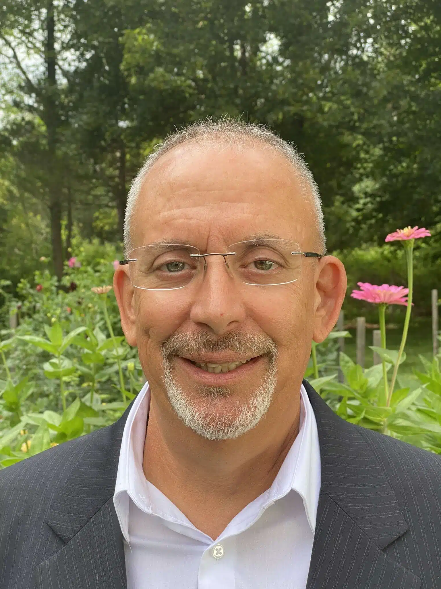 Smiling man in suit with nature background.